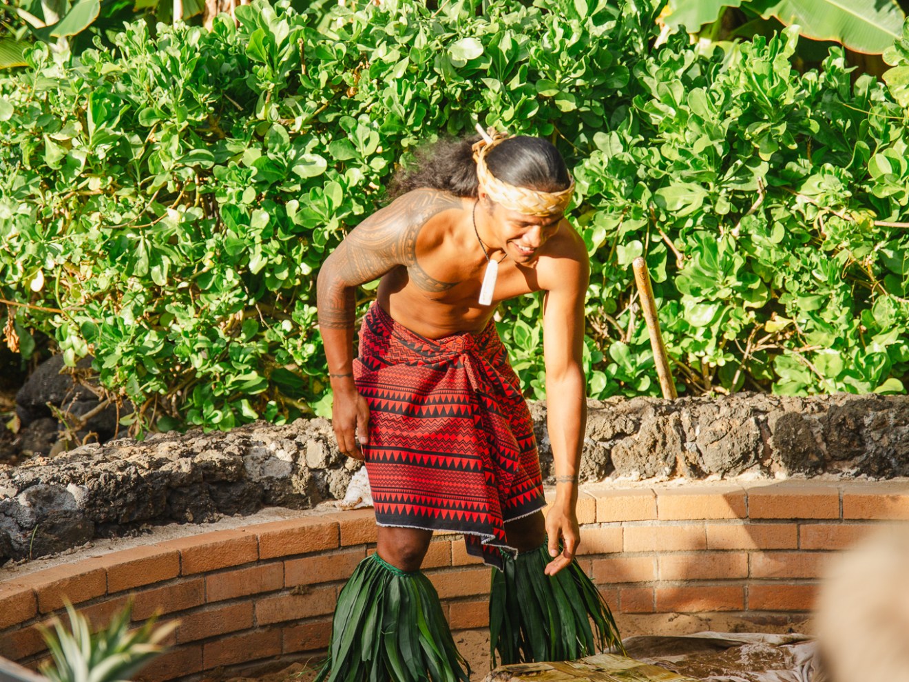 Man in Luau Attire Setting up a Fire