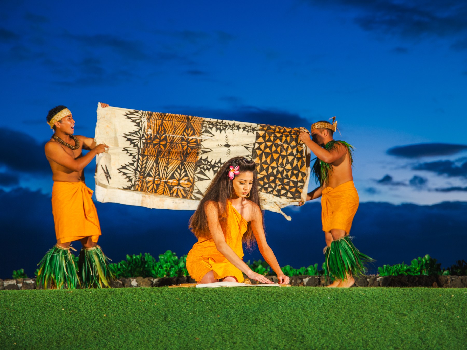 Woman kneeling with Men Holding an Animal Print Blanket Behind Her